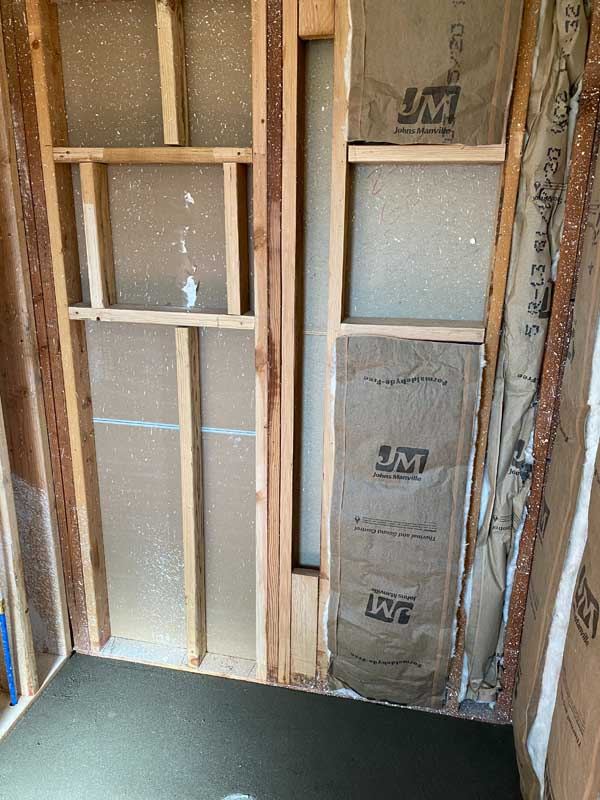 Bare stud wall and a new shower pan before tiling.