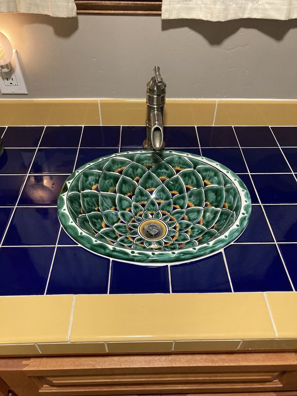 Hand-painted Talavera vessel sink set into a cobalt-blue tiled counter.