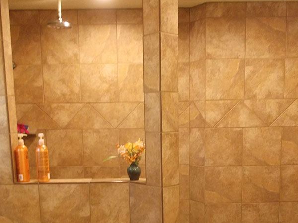 Travertine shower wall with a full-height recessed niche.